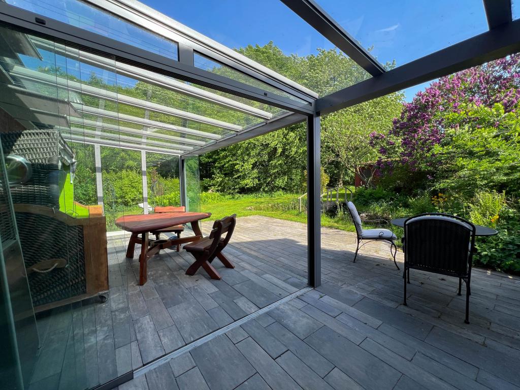Mehrfamilienhaus: Terrasse WE 1 mit Wintergarten